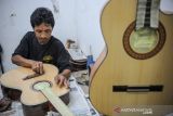 Pekerja menyelesaikan pembuatan gitar di Rumah Produksi Secco Guitar di Bandung, Jawa Barat, Rabu (5/1/2022). Kementerian Koperasi dan UMKM menyatakan, koperasi dan UMKM siap memasuki fase pemulihan transformatif memasuki tahun 2022, salah satunya dengan cara penambahan subsidi bunga KUR tiga persen yang telah disalurkan kepada 7,5 juta debitur dengan pembiayaan Rp278,38 triliun atau 97,81 persen dari target Rp285 triliun per 30 Desember 2021. ANTARA FOTO/Raisan Al Farisi/agr