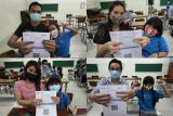 Foto kolase sejumlah orang tua menunjukkan Kartu Vaksinasi COVID-19  milik anaknya yang telah divaksin COVID-19 saat Vaksinasi Merdeka Anak di Surabaya, Jawa Timur, Rabu (5/1/2022). Polda Jawa Timur menggelar vaksinasi COVID-19 bagi anak umur 6-11 tahun secara serentak di 115 lokasi di Jawa Timur dengan menargetkan 2,5 juta anak penerima vaksin. Antara Jatim/Didik Suhartono/zk