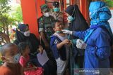 Petugas memenangkan seorang anak sebelum mengikuti vaksinasi COVID-19 di SDN 6 Margadadi, Indramayu, Jawa Barat, Kamis (6/1/2022). Vaksinasi COVID-19 untuk anak umur 6-11 tahun tersebut bertujuan mempercepat dan memperluas pelaksanaan PTM (Pembelajaran Tatap Muka) di seluruh wilayah Indonesia. ANTARA FOTO/Dedhez Anggara/agr