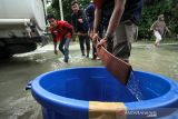 Relawan Palang Merah Indonesia (PMI) membagikan air untuk warga terdampak banjir di Desa Ketapang, Aceh Utara, Aceh, Kamis (6/1/2022). PMI Aceh Utara memberikan bantuan air bersih, kain sarung, selimut, kelambu dan pakaian laik pakai kepada korban banjir di daerah tersebut. ANTARA FOTO/Rahmad