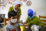 Dua orang tenaga kesehatan menggunakan topeng pahlawan super saat menyuntikkan vaksin COVID-19 kepada anak usia 6-11 tahun di RSIA Tambak, Jakarta, Rabu (5/1/2022). Penggunaan topeng pahlawan super tersebut bertujuan menarik minat anak-anak untuk mengikuti program vaksinasi COVID-19. ANTARA FOTO/Rivan Awal Lingga/wsj.