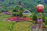 Pengunjung menikmati suasana wisata Jembatan Cinta di Desa Mekarbuana, Tegalwaru, Karawang, Jawa Barat, Minggu (9/1/2022). Menparekraf Sandiaga Uno mengatakan sektor pariwisata dan ekonomi kreatif (parekraf) dapat berkontribusi besar bagi kebangkitan ekonomi di tanah air pada tahun 2022. ANTARA FOTO/M Ibnu Chazar/agr