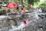 Sejumlah pengunjung bermain air di Bumi Perkemahan Bedengan Selorejo, Malang, Jawa Timur, Minggu (9/1/2022). Wisata alam di kawasan Perhutani Kesatuan Pemangkuan Hutan (KPH) Malang tersebut saat akhir pekan ramai pengenjung dengan tiket masuk sangat terjangkau. Antara Jatim/Prasetia Fauzani/zk