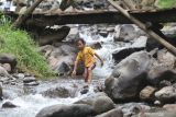 Seorang anak bermain air di Bumi Perkemahan Bedengan Selorejo, Malang, Jawa Timur, Minggu (9/1/2022). Wisata alam di kawasan Perhutani Kesatuan Pemangkuan Hutan (KPH) Malang tersebut saat akhir pekan ramai pengenjung dengan tiket masuk sangat terjangkau.  Antara Jatim/Prasetia Fauzani/zk