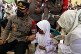 Kapolres Lhokseumawe AKBP Eko Hartanto (kiri) mendampingi seorang siswa saat vaksinasi COVID-19 dosis pertama untuk anak usia 6-11 tahun di Polres Lhokseumawe, Aceh, Senin (10/1/2022). Pemerintah mulai melaksanakan vaksinasi COVID-19 untuk anak usia 6-11 tahun dengan target sasaran 26,5 juta anak. ANTARA FOTO/Rahmad