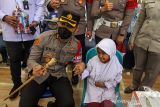 Kapolres Lhokseumawe AKBP Eko Hartanto (kiri) mendampingi seorang siswa saat vaksinasi COVID-19 dosis pertama untuk anak usia 6-11 tahun di Polres Lhokseumawe, Aceh, Senin (10/1/2022). Pemerintah mulai melaksanakan vaksinasi COVID-19 untuk anak usia 6-11 tahun dengan target sasaran 26,5 juta anak. ANTARA FOTO/Rahmad