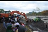 Warga mengevakuasi truk pasir yang terseret lahar hujan Gunung Semeru dengan bantuan alat berat di Sungai Regoyo, Desa Bagu, Pasirian, Lumajang, Jawa Timur, Selasa (11/1/2022). Di kawasan itu masih ada warga yang nekat menambang pasir di Sungai Regoyo meski rawan terjadi banjir lahar hujan Gunung Semeru. ANTARA FOTO/Seno/nym.