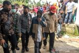 Menteri Sosial Tri Rismaharini berjalan menuju rumah ahli waris korban bencana banjir di Desa Meuria, Kecamatan Matang Kuli, Aceh Utara, Aceh, Selasa (11/1/2022). Mensos menyerahkan bantuan tanggap darurat senilai Rp1.9 miliar untuk membantu 52 ribu lebih korban banjir Aceh Utara, Aceh Timur, dan Aceh Tamiang. ANTARA FOTO/Rahmad