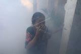 Seorang warga menutup hidungnya saat pengasapan (fogging) di Kelurahan Pesantren, Kota Kediri, Jawa Timur, Senin (10/1/2022). Pengasapan di daerah endemik wabah deman berdarah tersebut dilakukan guna mengendalikan perkembangbiakan nyamuk penyebar virus dengue sekaligus sebagai sarana edukasi kepada masyarakat pentingnya menjaga kebersihan lingkungan. ANTARA FOTO/Prasetia Fauzani/wsj.