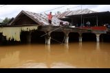 Warga naik ke atap rumahnya saat terjadi banjir di Desa Pengaron, Kabupaten Banjar, Kalimantan Selatan, Rabu (12/1/2022). Sebanyak 2.215 kepala keluarga (KK) terdampak banjir yang melanda delapan desa di Kecamatan Pengaron dan sebanyak 2008 rumah terendam. ANTARA FOTO/Bayu Pratama S/nym.