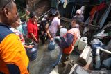  Petugas Badan Penanggulangan Bencana Daerah (BPBD) Kabupaten Pasuruan mengisi air bersih warga korban banjir di Desa Kedungringin Tengah, Beji, Pasuruan, Jawa Timur, Rabu (12/1/2022). Bantuan dari pemerintah daerah setempat itu ditujukan kepada warga yang kesulitan air bersih akibat banjir. Antara Jatim/Umarul Faruq/zk