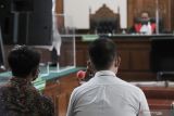 Dua terdakwa kasus penganiayaan wartawan Tempo Nurhadi, Brigadir Polisi Kepala Purwanto (kanan) dan Brigadir Polisi Muhammad Firman Subkhi (kiri)  menjalani sidang putusan di Pengadilan Negeri Surabaya, Surabaya, Jawa Timur, Rabu (12/1/2022). Kedua terdakwa tersebut divonis sepuluh bulan penjara karena terbukti bersalah dengan sengaja dan melawan hukum melakukan tindakan yang menghambat atau menghalangi kerja pers . Antara Jatim/Rizal Hanafi/Zk
