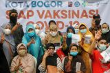 Sejumlah warga berfoto bersama usai mengikuti vaksinasi COVID-19 dosis ketiga (booster) di Puskesmas Semplak, Kota Bogor, Jawa Barat, Kamis (13/1/2022). Sebanyak 25 puskesmas dan 68 kelurahan di Kota Bogor menjadi lokasi pelaksanaan vaksinasi booster untuk masyarakat kategori lansia dan pelayan publik dengan target sebanyak 112.689 warga. ANTARA FOTO/Arif Firmansyah/hp.