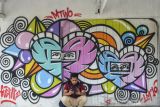 Warga bermain gawai di depan mural di Gang Komplek Perkantoran, Kertasari, Kabupaten Ciamis, Jawa Barat, Jumat (14/1/2022). Seni mural yang dibuat oleh 97 seniman 