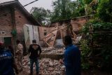 Warga melihat kondisi rumah yang rusak akibat gempa di Kadu Agung Timur, Lebak, Banten, Jumat (14/1/2022). Gempa berkekuatan 6,7 SR tersebut mengakibatkan sejumlah rumah rusak. ANTARA FOTO/Muhammad Bagus Khoirunas/rwa.
