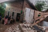 Warga melihat kondisi rumah yang rusak akibat gempa di Kadu Agung Timur, Lebak, Banten, Jumat (14/1/2022). Gempa berkekuatan 6,7 SR tersebut mengakibatkan sejumlah rumah rusak. ANTARA FOTO/Muhammad Bagus Khoirunas/rwa.
