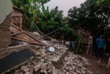 Warga melihat kondisi rumah yang rusak akibat gempa di Kadu Agung Timur, Lebak, Banten, Jumat (14/1/2022). Gempa berkekuatan 6,7 SR tersebut mengakibatkan sejumlah rumah rusak. ANTARA FOTO/Muhammad Bagus Khoirunas/rwa.
