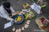 Budayawan mengambil nasi tumpeng simbol sesajian untuk dimakan saat Aksi Save Sesajen (sesajian) Damai Untuk Tradisi Nusantara di depan Monumen Perjuangan Rakyat, Bandung, Jawa Barat, Minggu (16/1/2022). Aksi tersebut dilakukan sebagai respon damai terhadap peristiwa perusakan sesajen di Gunung Semeru yang dianggap menciderai salah satu simbol kebhinekaan dan tradisi rasa syukur masyarakat adat nusantara yang sudah ada sejak dulu. ANTARA FOTO/Novrian Arbi/agr