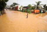 Warga melintasi banjir di Desa Kedawung, Grati, Pasuruan, Jawa Timur, Selasa (18/1/2022). Banjir setinggi satu meter yang disebabkan hujan dengan intensitas tinggi tersebut mengakibatkan belasan desa di tiga kecamatan wilayah timur Kabupaten Pasuruan terendam dan aktivitas masyarakat terganggu. Antara Jatim/Umarul Faruq/zk