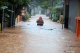 Warga melintasi banjir di Desa Kedawung, Grati, Pasuruan, Jawa Timur, Selasa (18/1/2022). Hujan deras dengan intensitas tinggi tersebut mengakibatkan belasan desa di tiga kecamatan wilayah timur Kabupaten Pasuruan terendam banjir dengan ketinggian hingga satu meter.  Antara Jatim/Umarul Faruq/zk