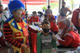 Seorang badut menghibur anak-anak saat mengikuti vaksinasi COVID-19 di Indramayu, Jawa Barat, Rabu (19/1/2022). Hiburan berupa badut dihadirkan saat vaksinasi untuk menarik minat anak-anak mengikuti vaksinasi COVID-19. ANTARA FOTO/Dedhez Anggara/agr