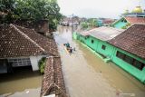 Warga melintasi banjir di Desa Rejoso, Kecamatan Rejoso, Pasuruan, Jawa Timur, Rabu (19/1/2022). Menurut data Badan Penanggulangan Bencana Daerah (BPBD) Kabupaten Pasuruan, sebanyak 5.017 Kepala Keluarga (KK) di enam kecamatan terdampak banjir akibat luapan sungai Rejoso. Antara Jatim/Umarul Faruq/zk