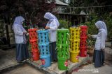 Sejumlah siswa merawat vertikal komposter di pusat edukasi lingkungan hidup di Cipadung Kulon, Bandung, Jawa Barat, Kamis (20/1/2022). Pusat edukasi lingkungan hidup yang dikelola oleh Koperasi Wahana Usaha Jaya tersebut menyediakan layanan untuk edukasi pengelolaan sampah, bercocok tanam, peternak dan perikanan secara gratis bagi masyarakat khususnya pelajar dari tingkat PAUD hingga mahasiswa. ANTARA FOTO/Raisan Al Farisi/agr