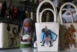  Perajin membuat tas hias dengan teknik decoupage bergambar wayang untuk dikirim ke berbagai kota di rumah produksi Fianoel Decoupage, Malang, Jawa Timur, Jumat (21/1/2022). Perajin tas hias setempat berupaya meningkatkan penjualan dengan menggenjot pemasaran di pasar digital serta berinovasi dengan kreasi lukis tangan dan teknik decoupage bergambar wayang. Antara Jatim/Ari Bowo Sucipto/zk