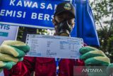 Petugas menunjukkan sertfikat kelaikan emisi kendaraan dinas roda empat di halaman Gedung Sate, Bandung, Jawa Barat, Selasa (25/1/2022). Pemerintah Jawa Barat memulai pelaksanaan kelaikan emisi kendaraan bagi aparatur sipil negara sebagai awal pencanangan kawasan emisi bersih dengan target penerapan di seluruh wilayah Jawa Barat. ANTARA FOTO/Novrian Arbi/agr