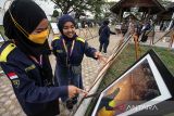 Pengunjung melihat foto yang dipajang pada pameran foto hasil karya Mahasiswa FISIP Unimal di kompleks Museum Lhokseumawe, Aceh, Senin (24/1/2022). Pameran yang menampilkan 274 karya foto mahasiswa ilmu komunikasi FISIP Unimal tersebut mengusung tema Aceh Bangkit Melawan COVID-19 dan berlangsung hingga 26 Januari 2022. ANTARA FOTO/Rahmad