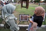 Pengunjung melihat foto yang dipajang pada pameran foto hasil karya Mahasiswa FISIP Unimal di kompleks Museum Lhokseumawe, Aceh, Senin (24/1/2022). Pameran yang menampilkan 274 karya foto mahasiswa ilmu komunikasi FISIP Unimal tersebut mengusung tema Aceh Bangkit Melawan COVID-19 dan berlangsung hingga 26 Januari 2022. ANTARA FOTO/Rahmad