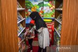 Seorang anak didampingi orang taunya memilah buku bacaan di Dinas Perpustakaan dan Kearsipan Kabupaten Ciamis, Jawa Barat, Rabu (26/1/2022). Data UNESCO menyebutkan Indonesia menempati urutan kedua dari bawah soal literasi dunia yang berarti minat baca sangat rendah dengan persentase 0,001 persen atau dari 1.000 orang Indonesia hanya satu orang yang rajin membaca. ANTARA FOTO/Adeng Bustomi/agr