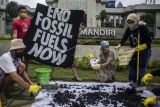 Sejumlah aktivis Jeda Untuk Iklim melakukan aksi di depan Plaza Mandiri, Jakarta, Selasa (25/1/2022). Aksi bersih-bersih energi kotor dari batu bara tersebut mengingatkan para lembaga keuangan untuk segera melepaskan diri dari lingkaran bisnis energi batu bara. ANTARA FOTO/Aprillio Akbar/rwa.