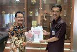 Kepala Biro Perum Lembaga Kantor Berita Nasional (LKBN) ANTARA Jawa Timur, Slamet Hadi Purnomo (kiri) memberikan cinderamata buku Surga di Secangkir Kopi karya jurnalis ANTARA Biro Jawa Timur kepada Kepala Dinas Komunikasi dan Informatika (Diskominfo) Kota Malang Nur Widianto di sela kunjungannya di Kota Malang, Jawa Timur,  Kamis (27/1/2022). Kunjungan itu bertujuan untuk mempererat silaturahim sekaligus meningkatkan kerja sama, khususnya dalam diseminasi informasi pembangunan kepada masyarakat luas.Antara Jatim/Vicki Febrianto