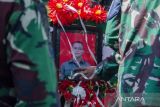 Prajurit TNI memegang foto Prajurit TNI AD Sertu Anumerta Mochamad Rizal Maulana Arifin saat upacara militer pemakaman di Taman Makam Pahlawan Cikutra, Bandung, Jawa Barat, Sabtu (19/1/2022). Upacara pemakaman Prajurit TNI AD Sertu Anumerta Rizal Maulana Arifin yang gugur akibat kontak tembak dengan Kelompok Kriminal Bersenjata (KKB) di Kabupaten Puncak, Papua dipimpin langsung oleh Kepala Staf Angkatan Darat Jenderal TNI Dudung Abdurachman sekaligus pemberian kenaikan pangkat penghormatan serta santunan kepada keluarga yang ditinggalkan. ANTARA FOTO/Novrian Arbi/agr