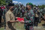 Kepala Staf Angkatan Darat Jenderal TNI Dudung Abdurachman (kanan) memberikan menyerahkan bendera Merah Putih kepada pihak keluarga usai mempimpin upacara militer pemakaman Prajurit TNI AD Sertu Anumerta Mochamad Rizal Maulana Arifin di Taman Makam Pahlawan Cikutra, Bandung, Jawa Barat, Sabtu (19/1/2022). Upacara pemakaman Prajurit TNI AD Sertu Anumerta Rizal Maulana Arifin yang gugur akibat kontak tembak dengan Kelompok Kriminal Bersenjata (KKB) di Kabupaten Puncak, Papua dipimpin langsung oleh Kepala Staf Angkatan Darat Jenderal TNI Dudung Abdurachman sekaligus pemberian kenaikan pangkat penghormatan serta santunan kepada keluarga yang ditinggalkan. ANTARA FOTO/Novrian Arbi/agr