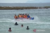 Sejumlah pengunjung menikmati liburan di pantai wisata Lampuuk, Kabupaten Aceh Besar, Aceh, Selasa (1/2/2022). Pada liburan tahun baru Imlek, sejumlah objek wisata pantai di daerah itu dipadati pengunjung yang datang dari berbagai daerah di provinsi Aceh, termasuk  wisatawan dari luar Aceh. ANTARA FOTO/Ampelsa