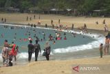 Sejumlah pengunjung menikmati liburan di pantai wisata Lampuuk, Kabupaten Aceh Besar, Aceh, Selasa (1/2/2022). Pada liburan tahun baru Imlek, sejumlah objek wisata pantai di daerah itu dipadati pengunjung yang datang dari berbagai daerah di provinsi Aceh, termasuk  wisatawan dari luar Aceh. ANTARA FOTO/Ampelsa