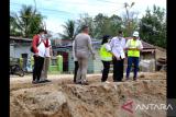 Bupati Sintang sekaligus KPM Perumdam Tirta Senentang dr Jarot Winarno didampingi Direktur Perumdam Tirta Senentang Jane Elisabeth Wuysang, Kepala Bagian Teknik Perumdam Rahman Putra dan Kepala Seksi Perencanaan Perumdam Novandy Roganda meninjau lokasi longsor di Kampung Ladang, Sintang, Kalimantan Barat, Rabu (2/2/2022). Longsor yang terjadi akibat hujan deras di lokasi pengerjaan Geobag pada Selasa (1/2/2022) malam hingga Rabu pagi tersebut mengakibatkan jaringan pipa distribusi Perumdam Tirta Senentang terkena dampaknya yaitu pada beberapa titik pipa distribusi pecah. Hal itu menyebabkan 752 pelanggan Perumdam Unit Layanan Sei Ana Baning pada wilayah sekitar pecahnya pipa mengalami penurunan tekanan. FOTO HO/Humas Perumdam Tirta Senentang