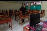 Petugas merapikan kursi di ruang kelas SMP Negeri 3 Denpasar, Bali, Jumat (4/2/2022). Pemerintah Kota Denpasar memutuskan untuk menghentikan pembelajaran tatap muka (PTM) mulai Jumat (4/2/2022) hingga batas waktu yang belum ditentukan dan dialihkan dengan pembelajaran secara daring menyusul terjadinya lonjakan kasus COVID-19 klaster sekolah. ANTARA FOTO/Nyoman Hendra Wibowo/nym.