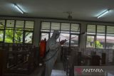 Petugas sekolah menyemprotkan cairan disinfektan di SMK Negeri 1 Ciamis, Kabupaten Ciamis, Jawa Barat, Senin (7/2/2022). Penyemprotan disinfektan di lingkungan sekolah dilakukan sebagai upaya mencegah penyebaran COVID-19 saat pemberlakuan pembelajaran tatap muka (PTM) 50 persen. ANTARA FOTO/Adeng Bustomi/agr
