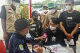 Petugas memeriksa kesehatan warga sebelum menerima vaksin COVID-19 saat pelaksanaan vaksinasi di Dinas Kesehatan Karawang, Jawa Barat, Jumat (11/2/2022). Menteri Koordinator Bidang Perekonomian Airlangga Hartarto mengatakan program vaksinasi COVID-19 dosis ketiga sudah dilaksanakan kepada 3,5 persen atau sekitar 6,3 juta penerima dari sasaran usia dewasa sebanyak 181,5 juta penerima. ANTARA FOTO/M Ibnu Chazar/agr