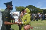 Prajurit TNI menerima karangan bunga dari keluarganya seusai upacara  penutupan pendidikan pertama bintara TNI AD  Tahun 2021 di Lapangan Blang Padang, Banda Aceh, Aceh, Jumat (11/2/2022). Sebanyak 273 bintara TNI AD yang baru dilantik itu, sekitar 70 persen di antaranya merupakan putra daerah Aceh dan mereka akan melanjutkan pendidikan tahap kedua kecabangan. ANTARA FOTO/Ampelsa