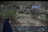 Seorang warga melihat fosil hewan laut yang berada di kawasan perbukitan di Kelurahan Tondo di Palu, Sulawesi Tengah, Sabtu (12/2/2022). Keberadaan fosil di daerah perbukitan yang menjadi penanda terjadinya tsunami di masa lampu tersebut menarik perhatian warga yang melintasi kawasan itu. ANTARA FOTO/Mohamad Hamzah/nym