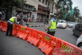 Petugas Dinas Perhubungan dan Satlantas Polrestabes Bandung menutup Jalan Asia Afrika di Bandung, Jawa Barat, Sabtu (12/2/2022). Pemerintah Kota Bandung kembali menutup sejumlah ruas jalan protokol di Bandung guna mencegah kerumunan pada masa PPKM level 3. ANTARA FOTO/Raisan Al Farisi/agr