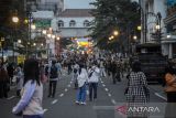 Warga berfoto di tengah jalan Jalan Asia Afrika yang di tutup di Bandung, Jawa Barat, Sabtu (12/2/2022). Pemerintah Kota Bandung kembali menutup sejumlah ruas jalan protokol di Bandung guna mencegah kerumunan pada masa PPKM level 3. ANTARA FOTO/Raisan Al Farisi/agr