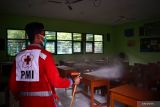 Petugas PMI menyemprotkan cairan disinfektan di lingkungan SMPN 10 Kota Madiun, Jawa Timur, Jumat (11/2/2022). Penyemprotan tersebut dilakukan menyusul adanya seorang murid yang dinyatakan positif terpapar COVID-19, dan pihak sekolah meliburkan kegiatan pembelajaran tatap muka hingga Kamis pekan depan. Antara Jatim/Siswowidodo/zk