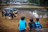 Sejumlah anak menyaksikan pengairan kolam retensi pengendali banjir di Pasir Kaliki, Cimahi, Jawa Barat, Rabu (16/2/2022). Pemerintah Kota Bandung dan Pemerintah Kota Cimahi berkolaborasi membangun kolam retensi untuk mengatasi banjir yang kerap terjadi di wilayah perbatasan antara Kota Cimahi dan Kota Bandung. ANTARA FOTO/Raisan Al Farisi/agr
