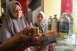 Pengusaha UMKM mengisi parfum dari bahan baku minyak Nilam ke dalam botol kemasan di Desa Batee Lapan Aceh Utara, Aceh, Selasa (15/2/2022). UMKM parfum industri rumahan binaan Kelompok Usaha Peningkatan Perekonomian Keluarga Sejahtera (KUPPK) tersebut masih bertahan dan berusaha menangkap peluang pemasaran melalui media sosial di tengah pandemi COVID-19. ANTARA FOTO/Rahmad