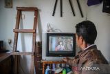 Petugas keamanan menonton tv melalui siaran analog di Cinunuk, Kabupaten Bandung, Jawa Barat, Kamis (17/2/2022). Kementerian Komunikasi dan Informatika akan melakukan penghentian siaran TV analog tahap pertama pada 30 April 2022 mendatang di 12 daerah di Jawa Barat. ANTARA FOTO/Raisan Al Farisi/agr
